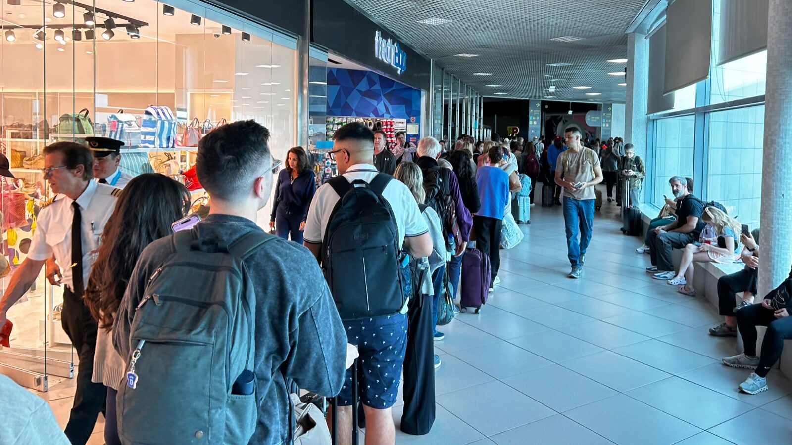 O aeroporto visto da fila: longa espera, resignação e lojas com poucos clientes